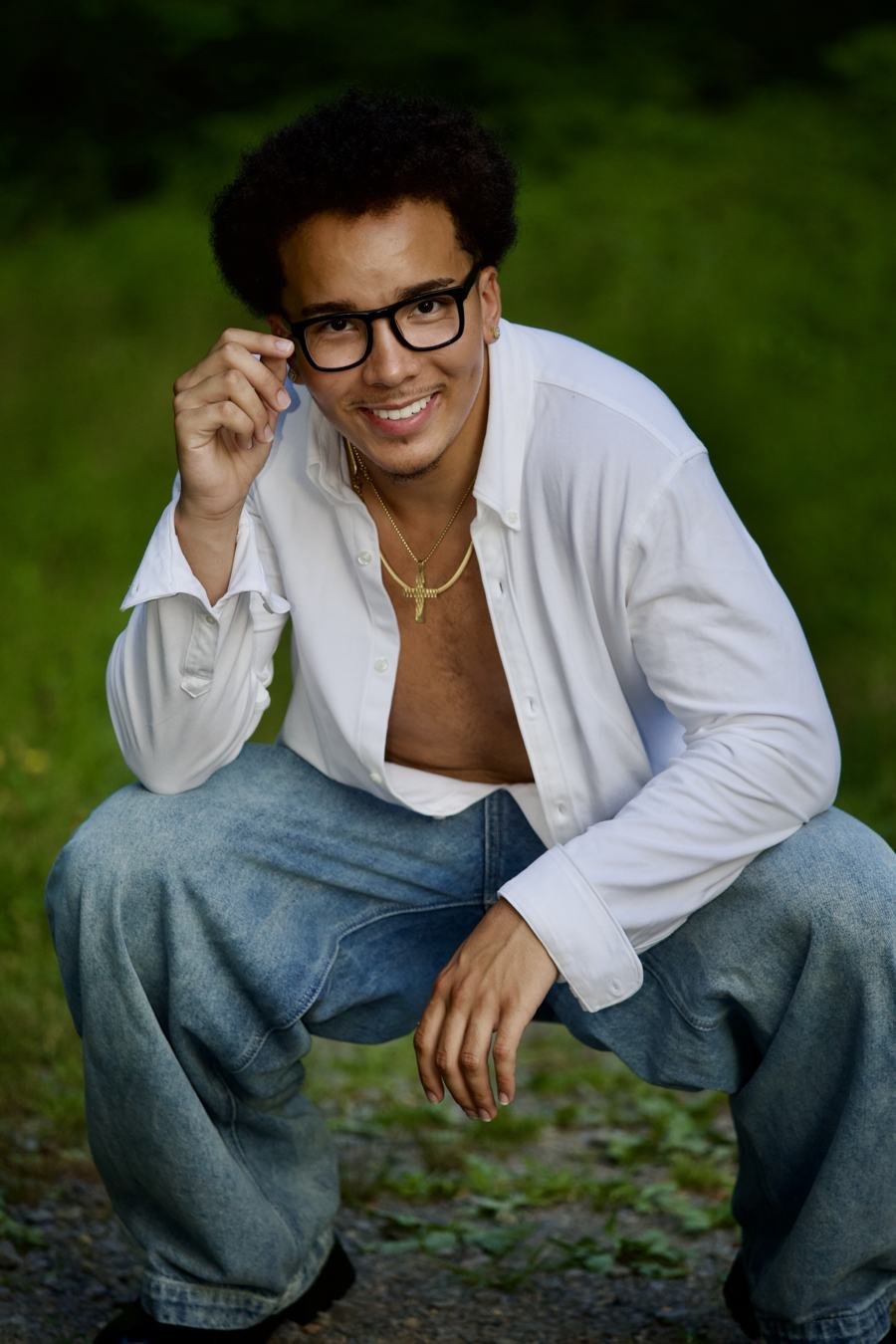 Jabari smiling while crouching in a white shirt